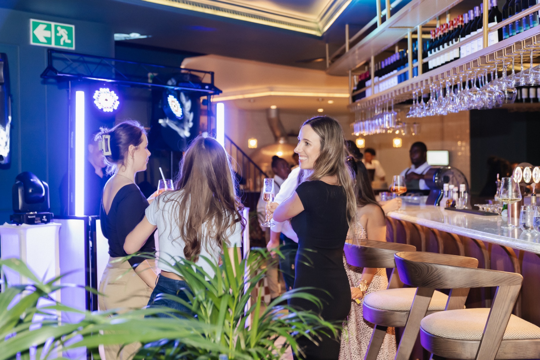 Guests with champagne at the Noah marble bar on First Thursdays