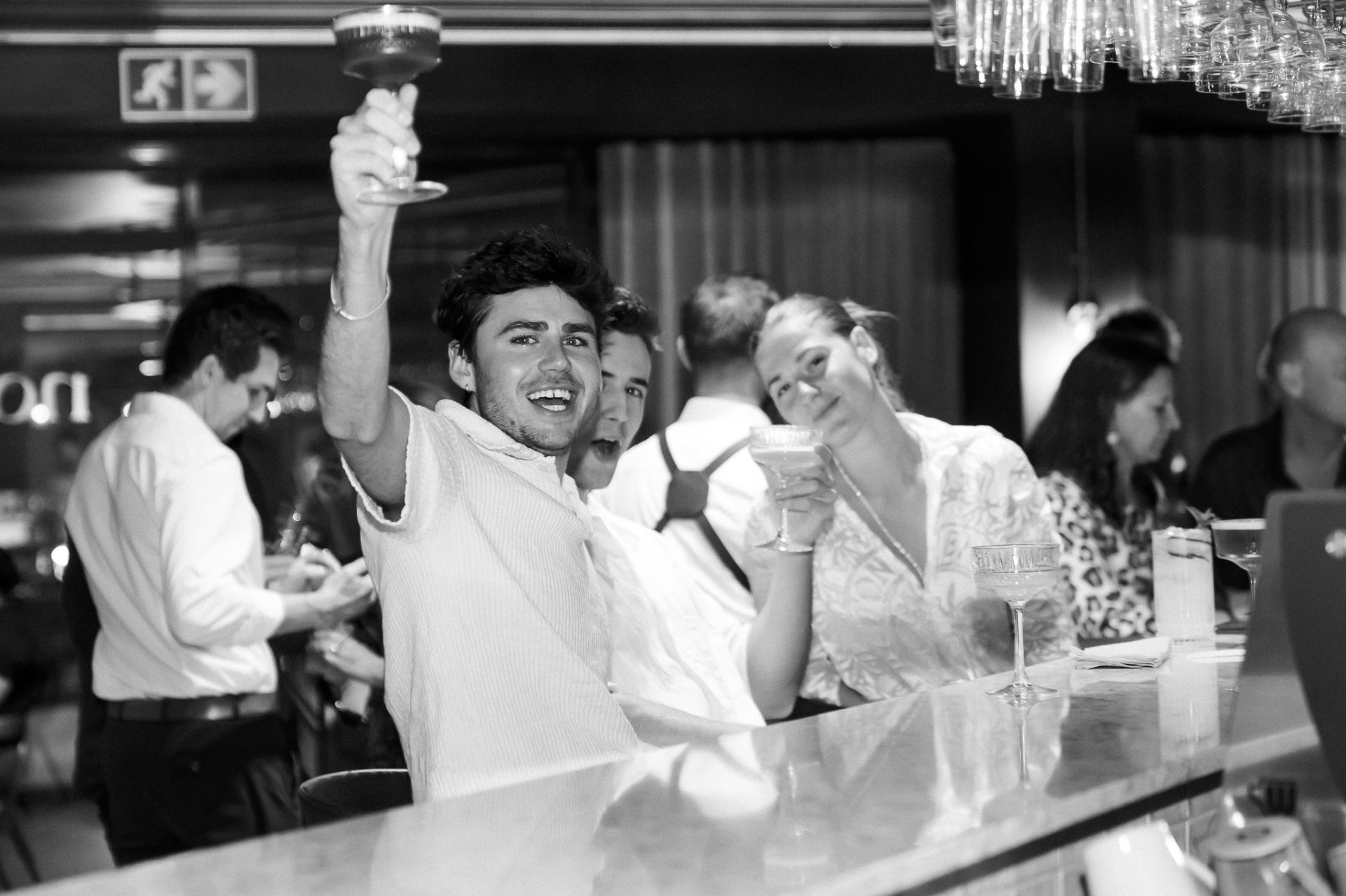 Guest raising a cocktail at the Noah bar during First Thursdays