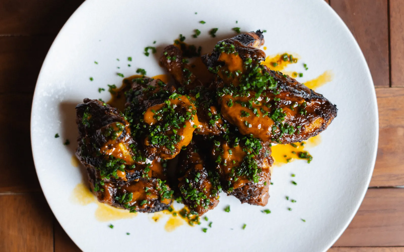 Wood-fired Karoo lamb rib cutlets plated with herbs at Noah Cape Town